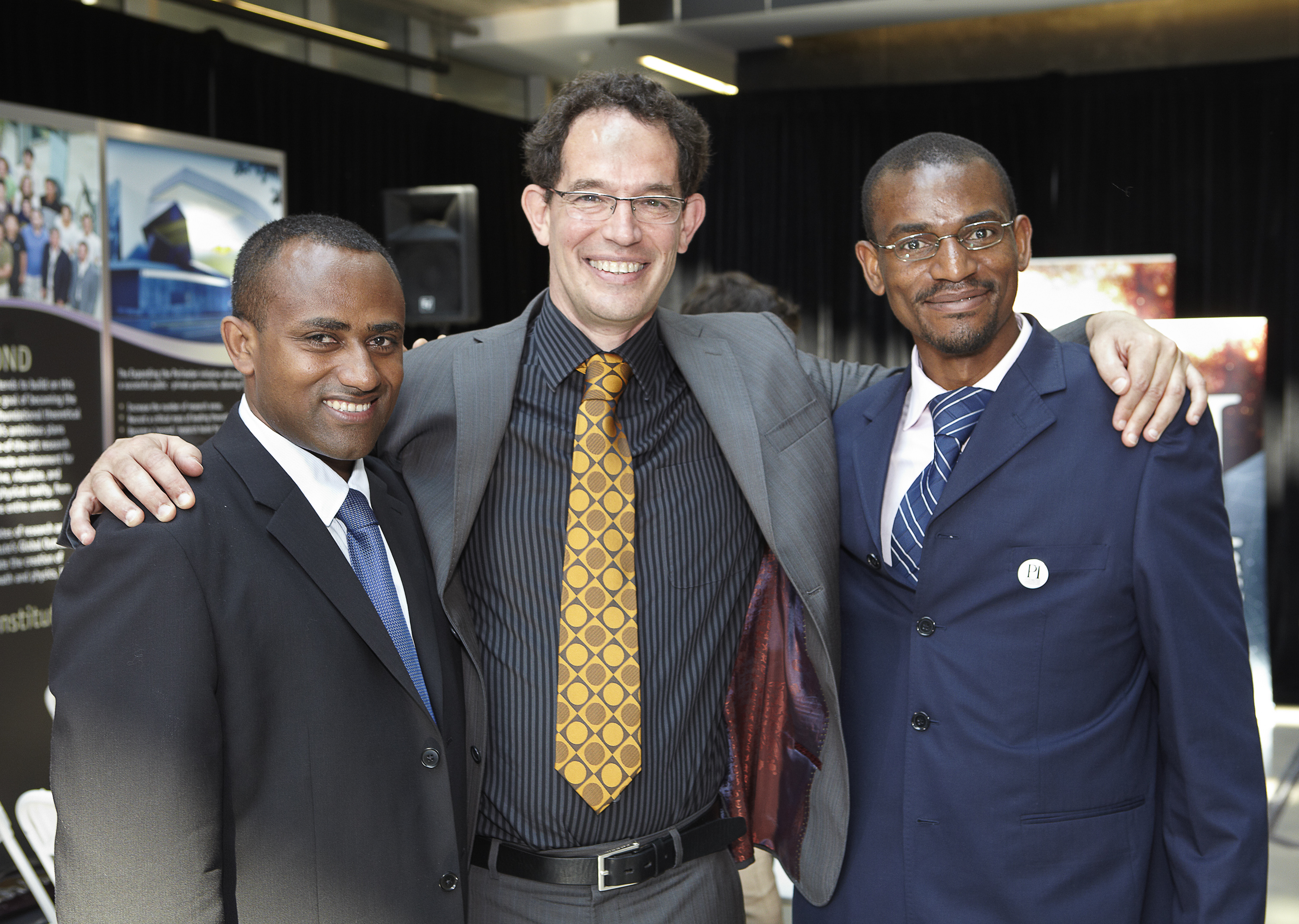 Neil Tuork posing with two AIMS alumni at the Global Outreach announcement with Prime Minister Stephen Harper