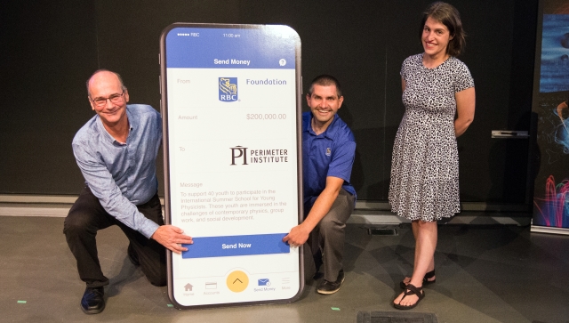 Two men kneeling beside an RBC sign and a woman standing beside