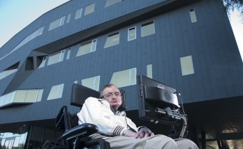 Stephen Hawking posing in front of the Stephen Hawking centre building at Perimeter Institue